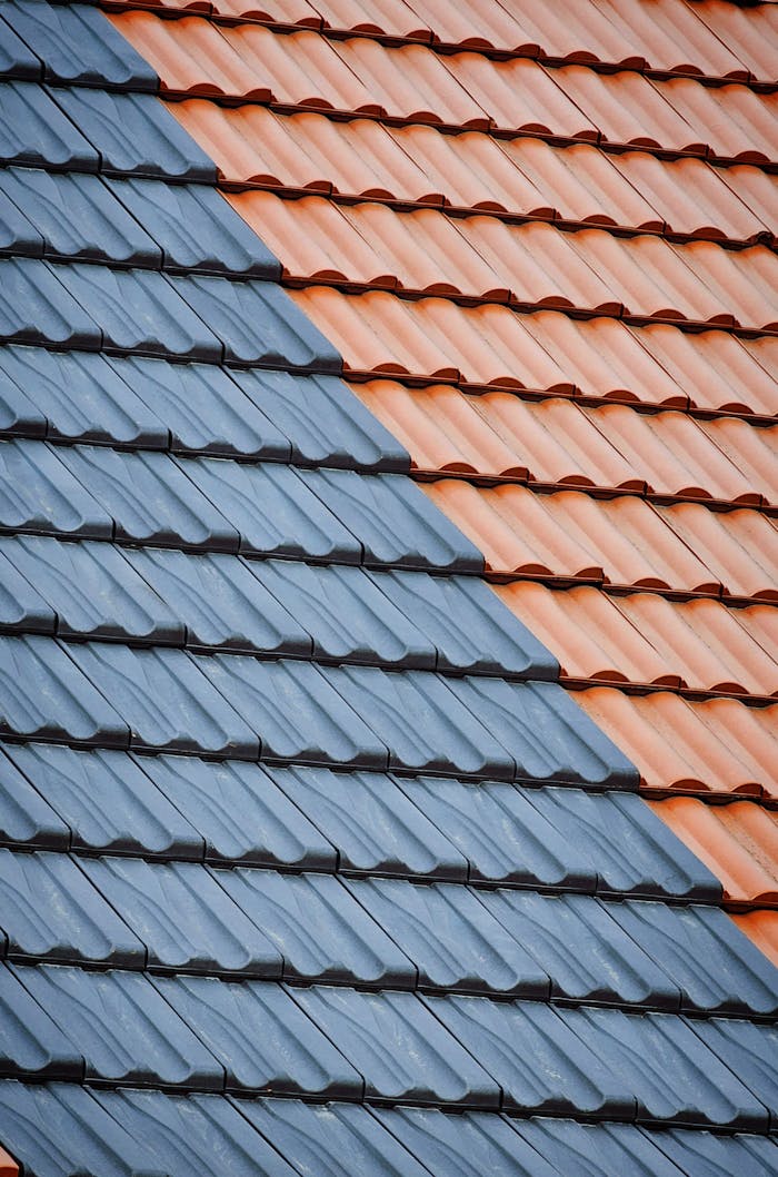 An abstract view of an orange and blue tiled roof showing geometric patterns and textures.